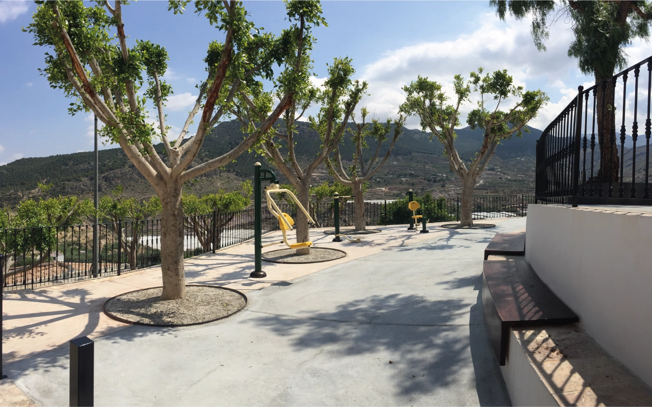 Parque urbano con sendero, juegos infantiles y árboles